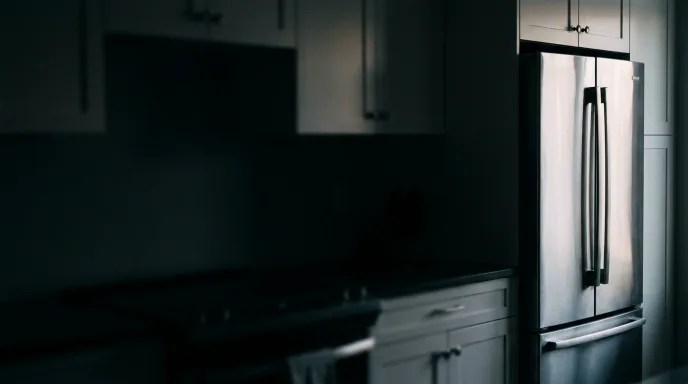 Technician repairing a refrigerator in a Syracuse kitchen