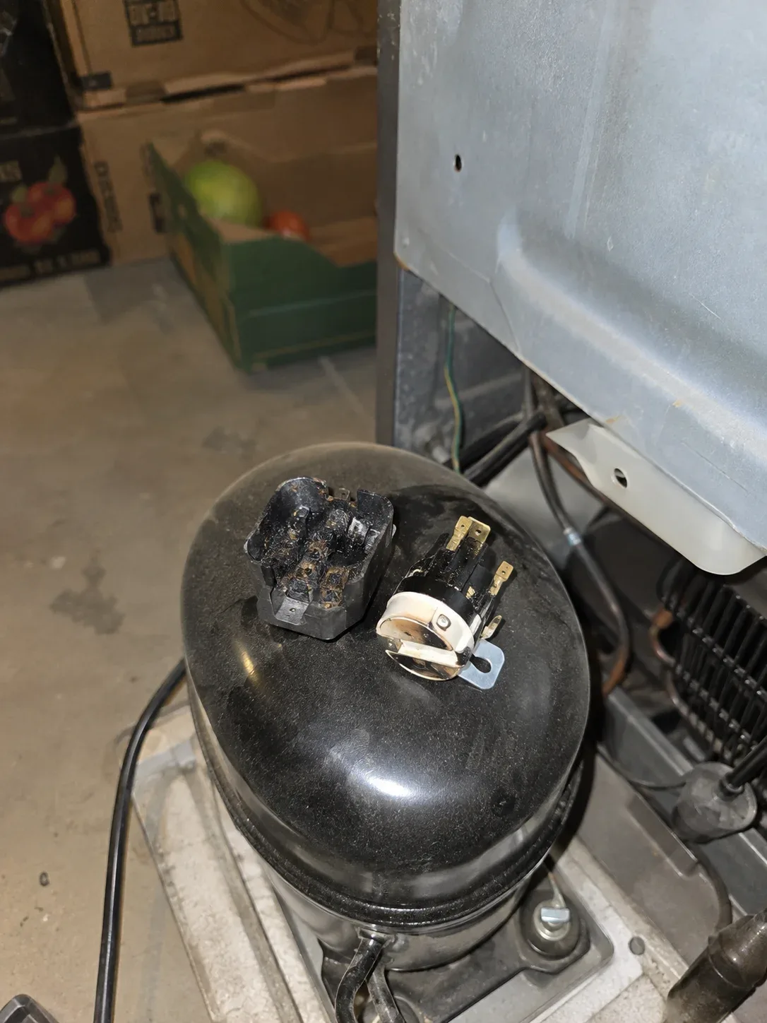 Upright freezer being repaired in a garage